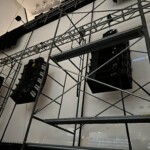 Line array loudspeakers behind high resolution theatrical screen surface